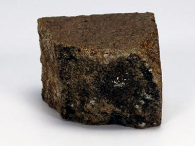 A rocha mostra-se alterada com substituição por sericite (mineral verde).